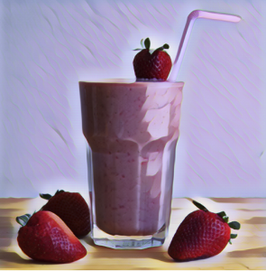 Strawberry smoothie with strawberries next to the glass 